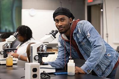 student with microscope