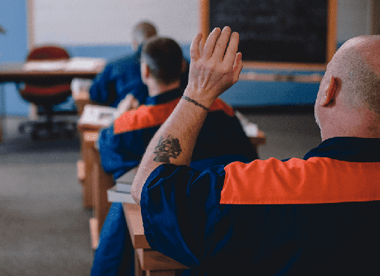 An inmate raising his hand in a classroom